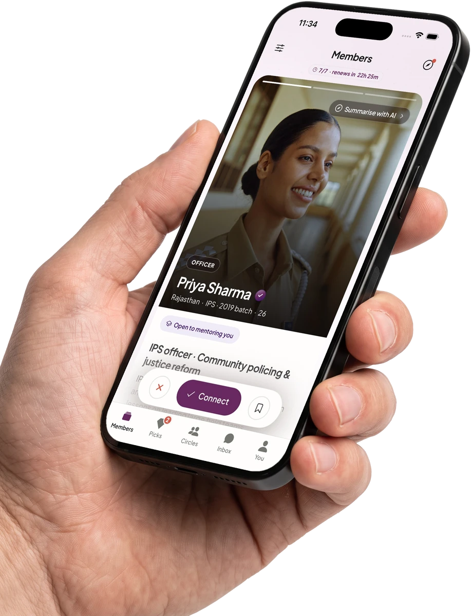 A hand holding a phone showing a member profile in the Officer Saathi app