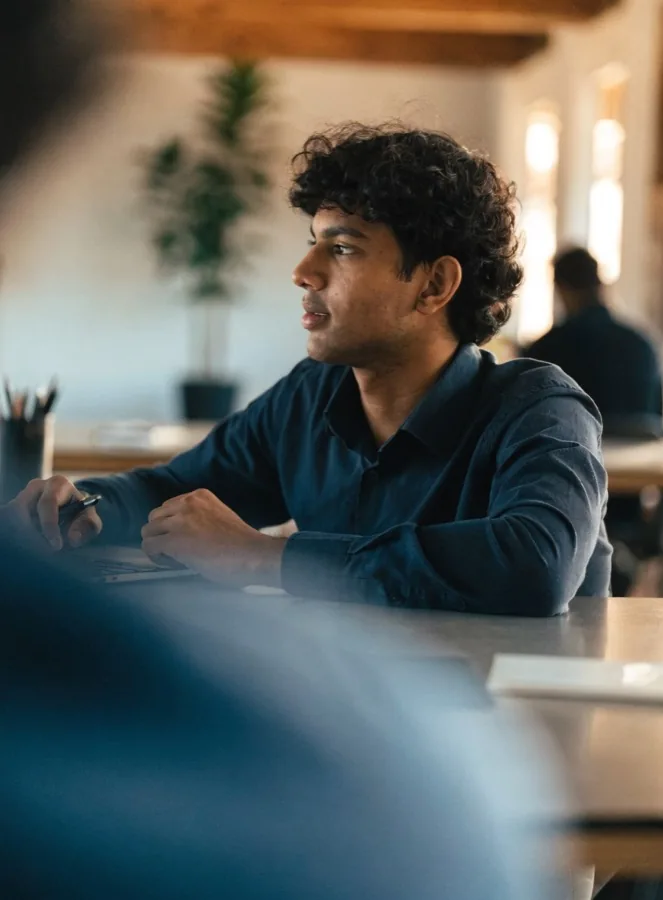 A young man working on a laptop in a bright office
